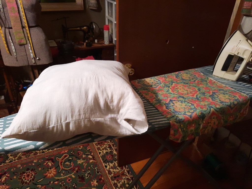 handsewn pillow using antique linen ticking being stuffed with wool