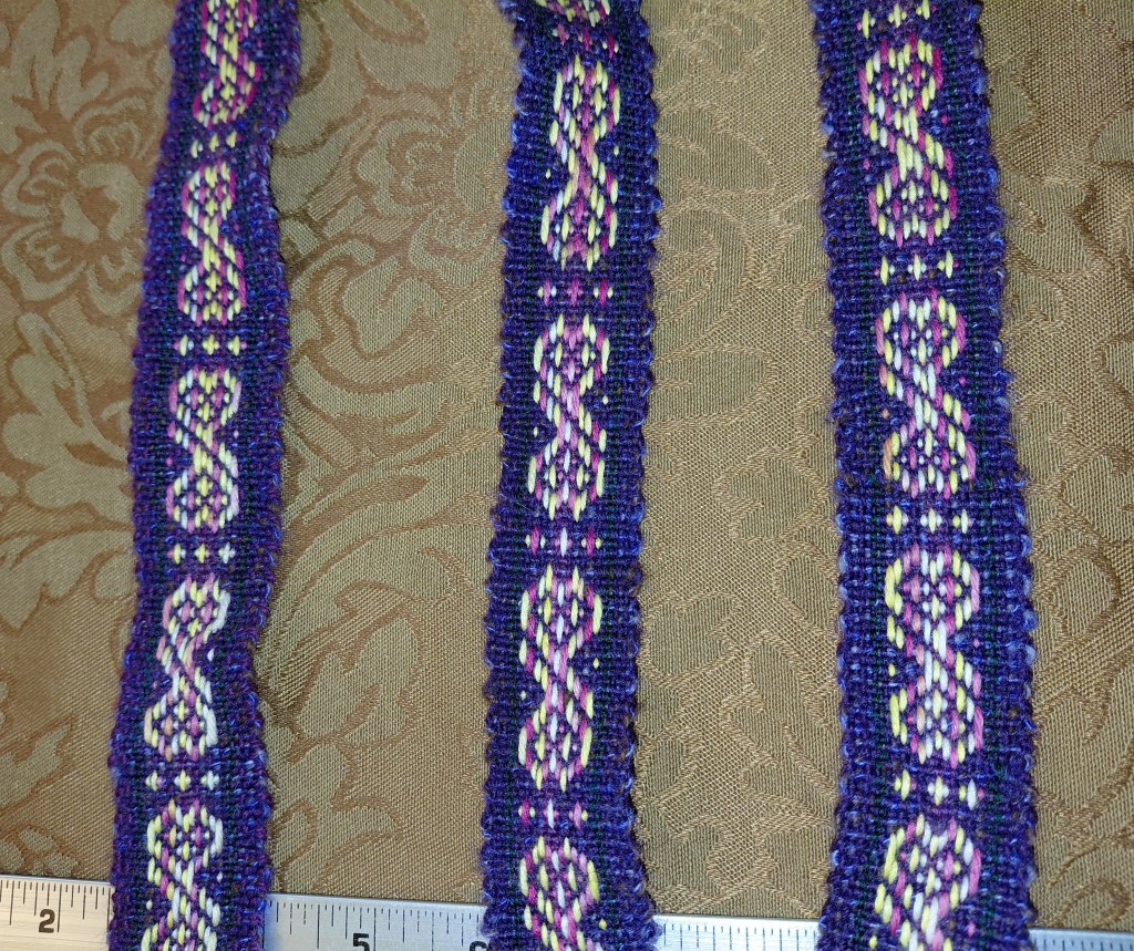 a handwoven wool baltic band belt featuring figure 8 hearts in pink and yellow on a purple background